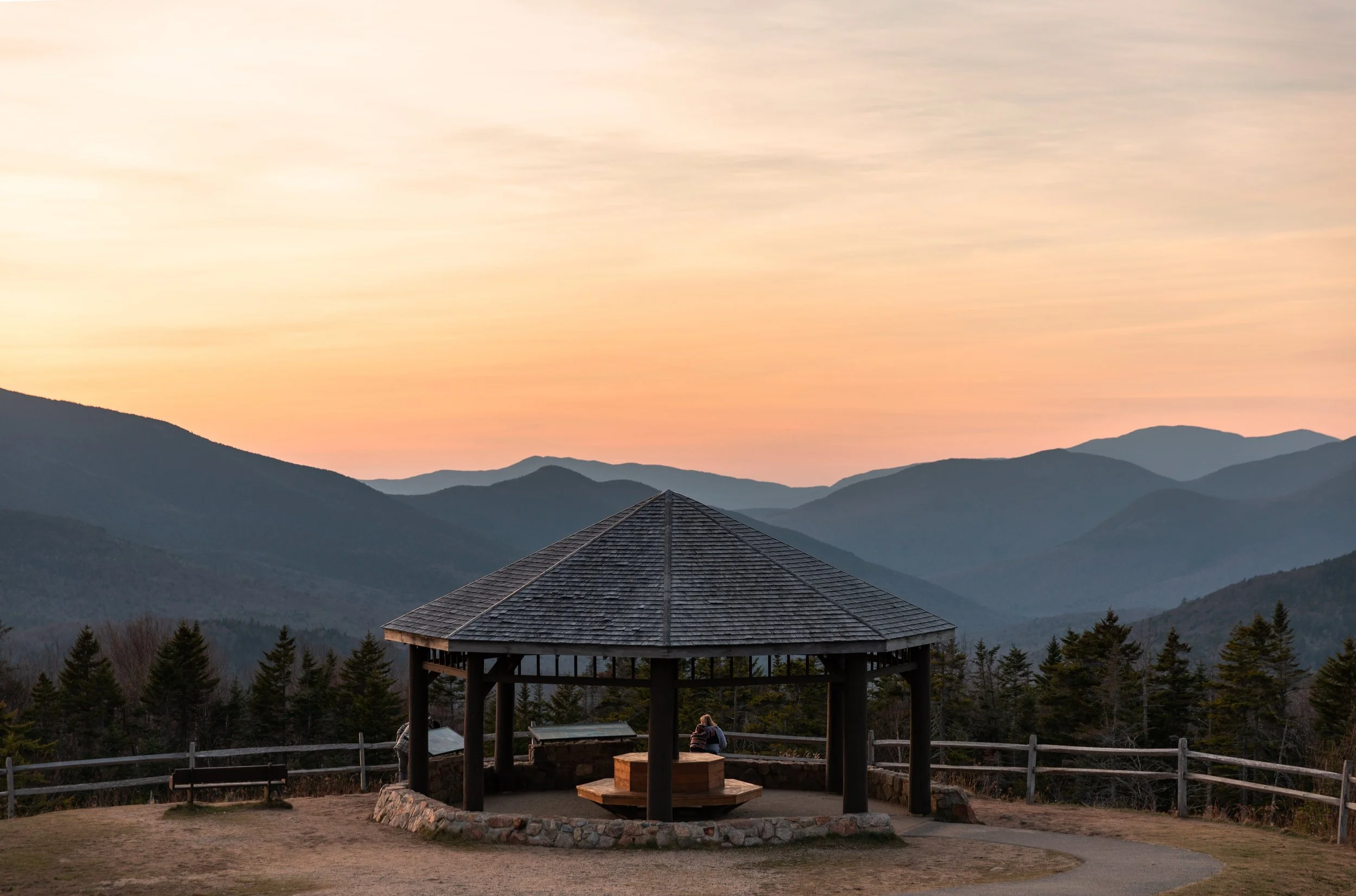 gazebo overlook on the kancamagus highway overlooking mountains during sunset