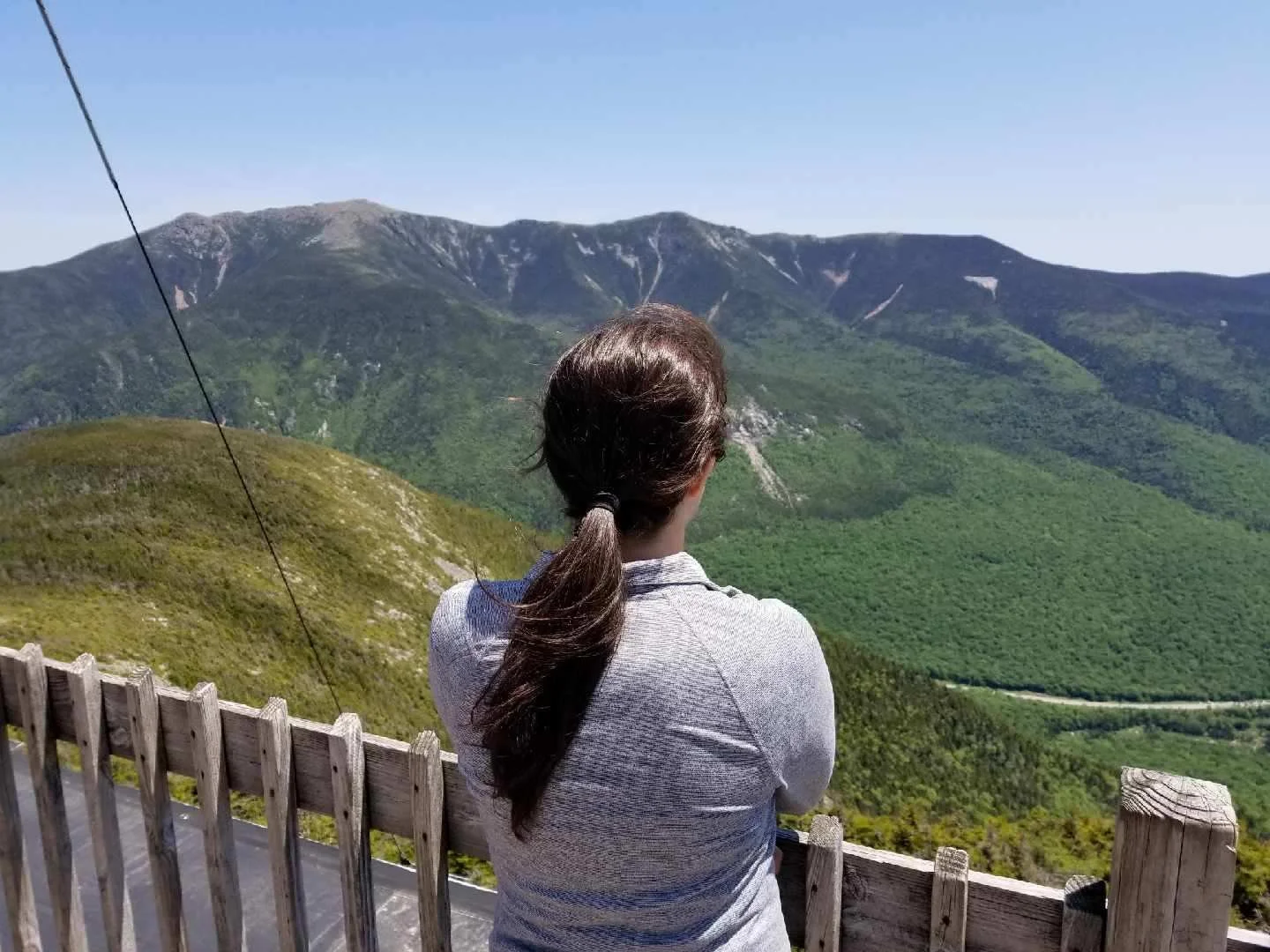 girl standing on viewing platform on cannon mountain looking out to mountains