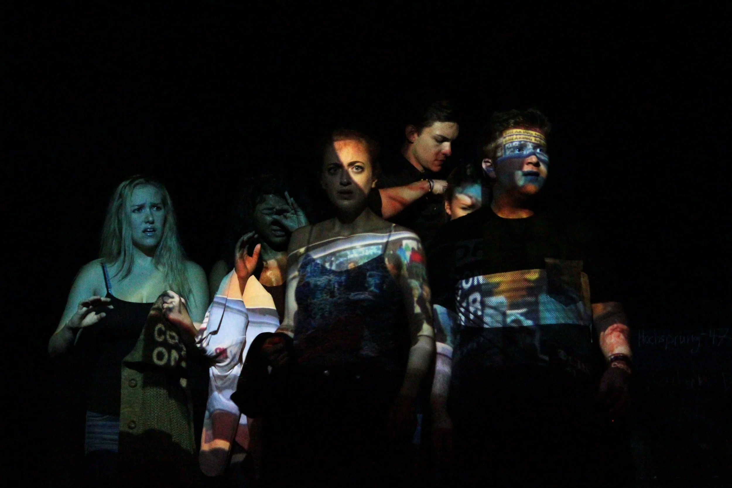 The community is bombarded with headlines, news reports and breaking news banners immediately after the shooting. Our projection designer, Jonas Hayes, created a projection sequence that played on the actors. It was paired with deafening and overlapping sound from various news clips designed by Kirk Ruby.