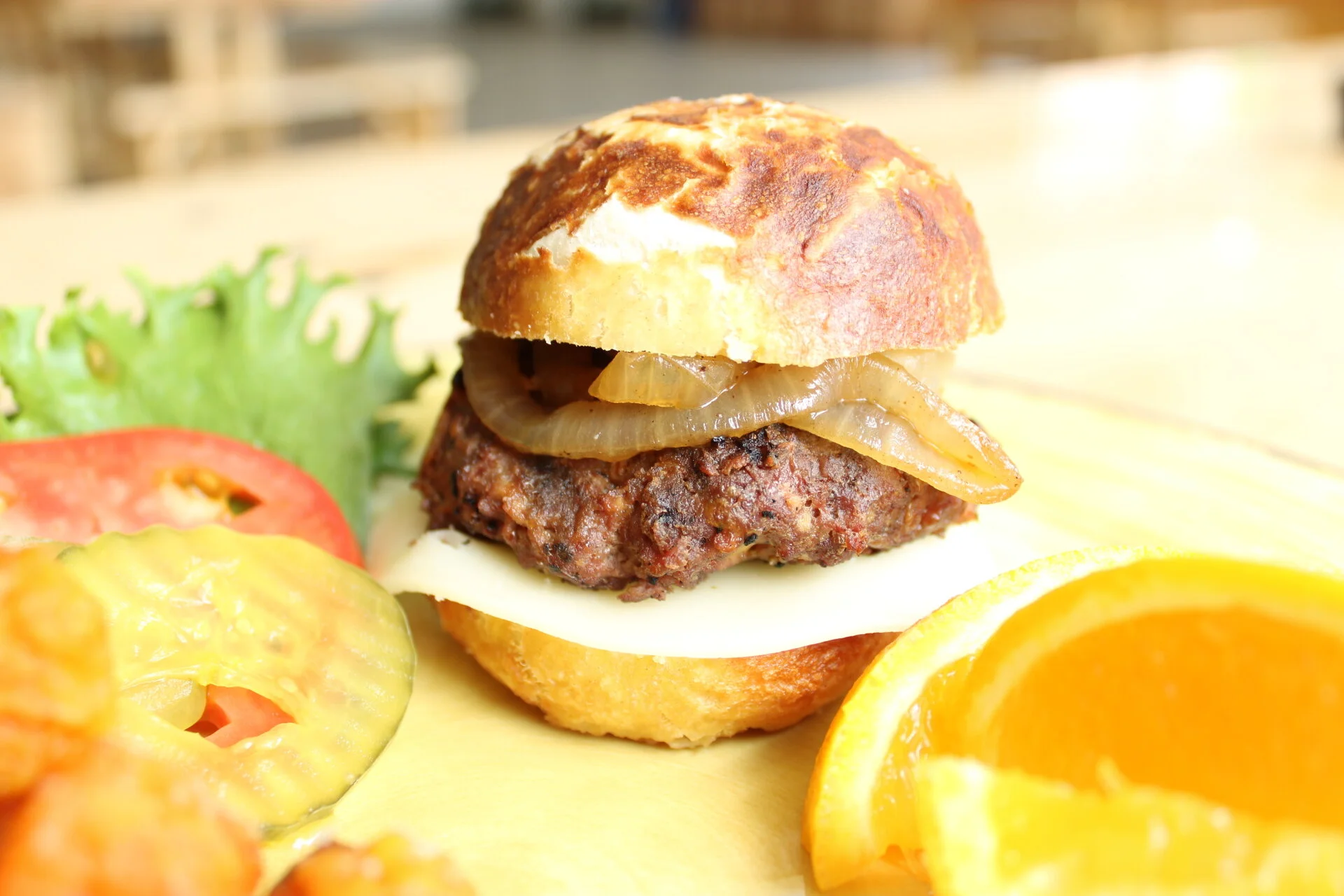 Hamburger with onions on pretzel bun