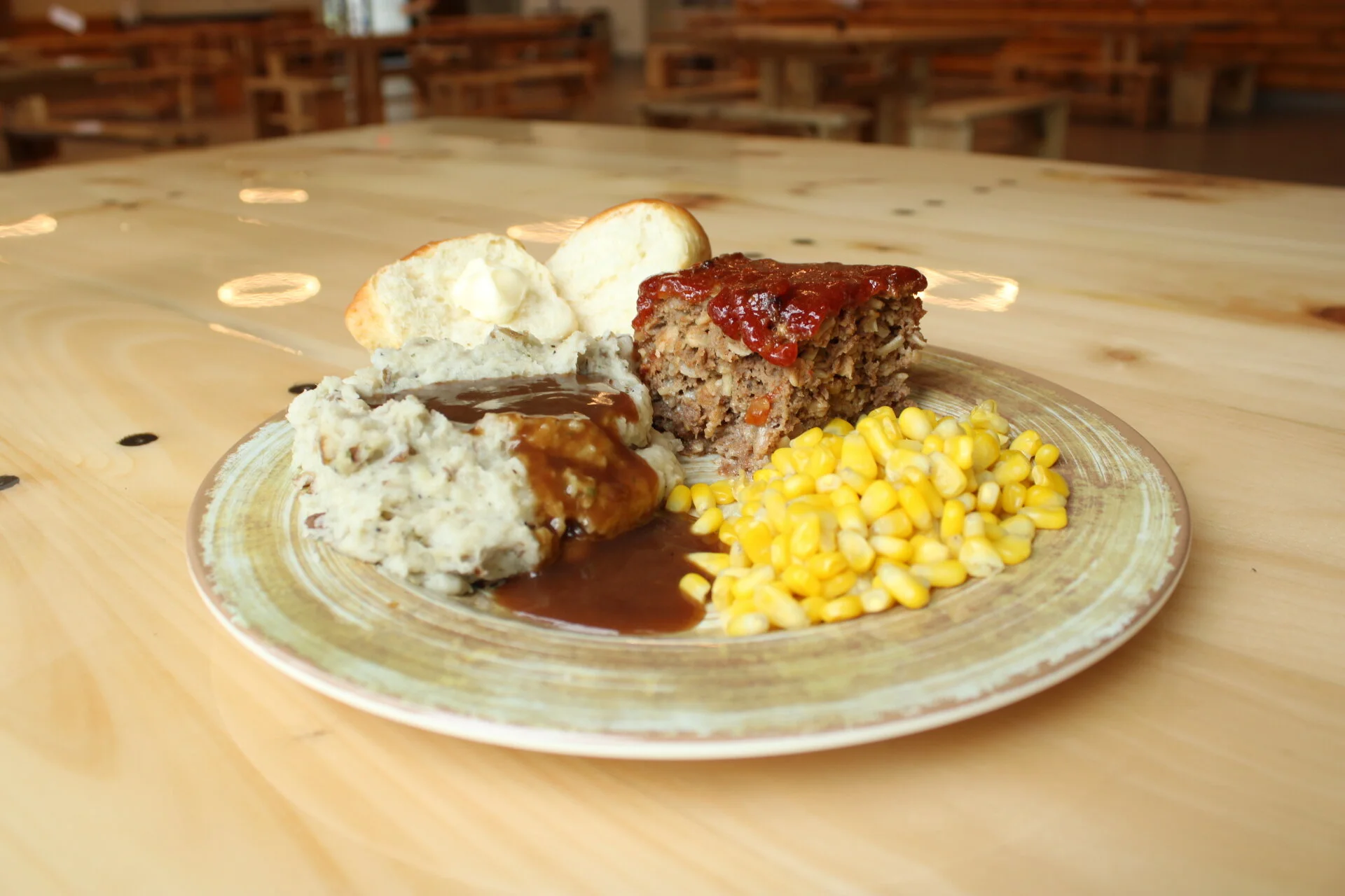 Meatloaf, mashed potatoes, corn, and roll