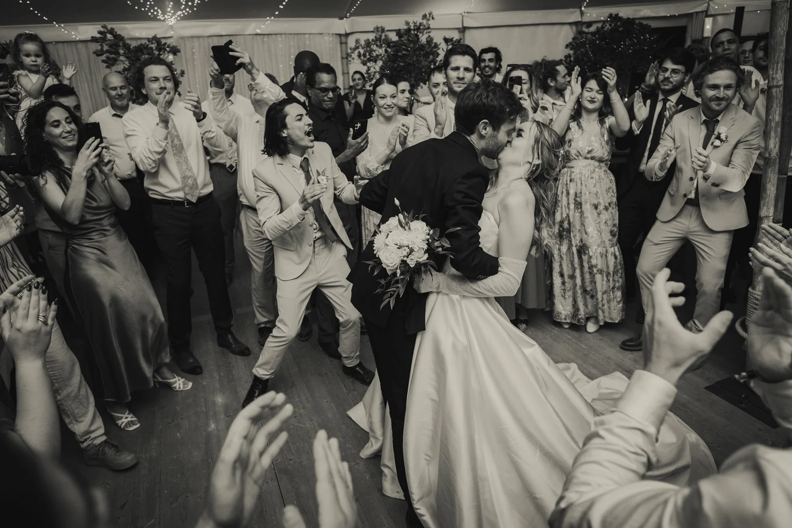 Friends and guests cheering for a fun entrance of bride and groom during dinner.