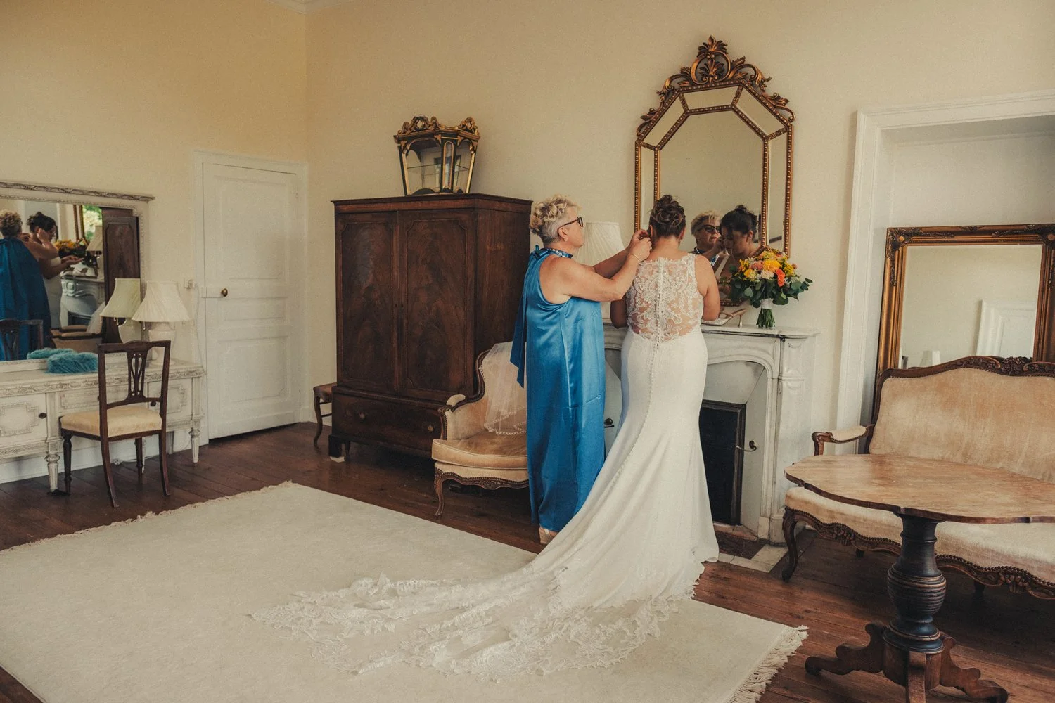 Bride getting ready with her mother inside château wedding venue