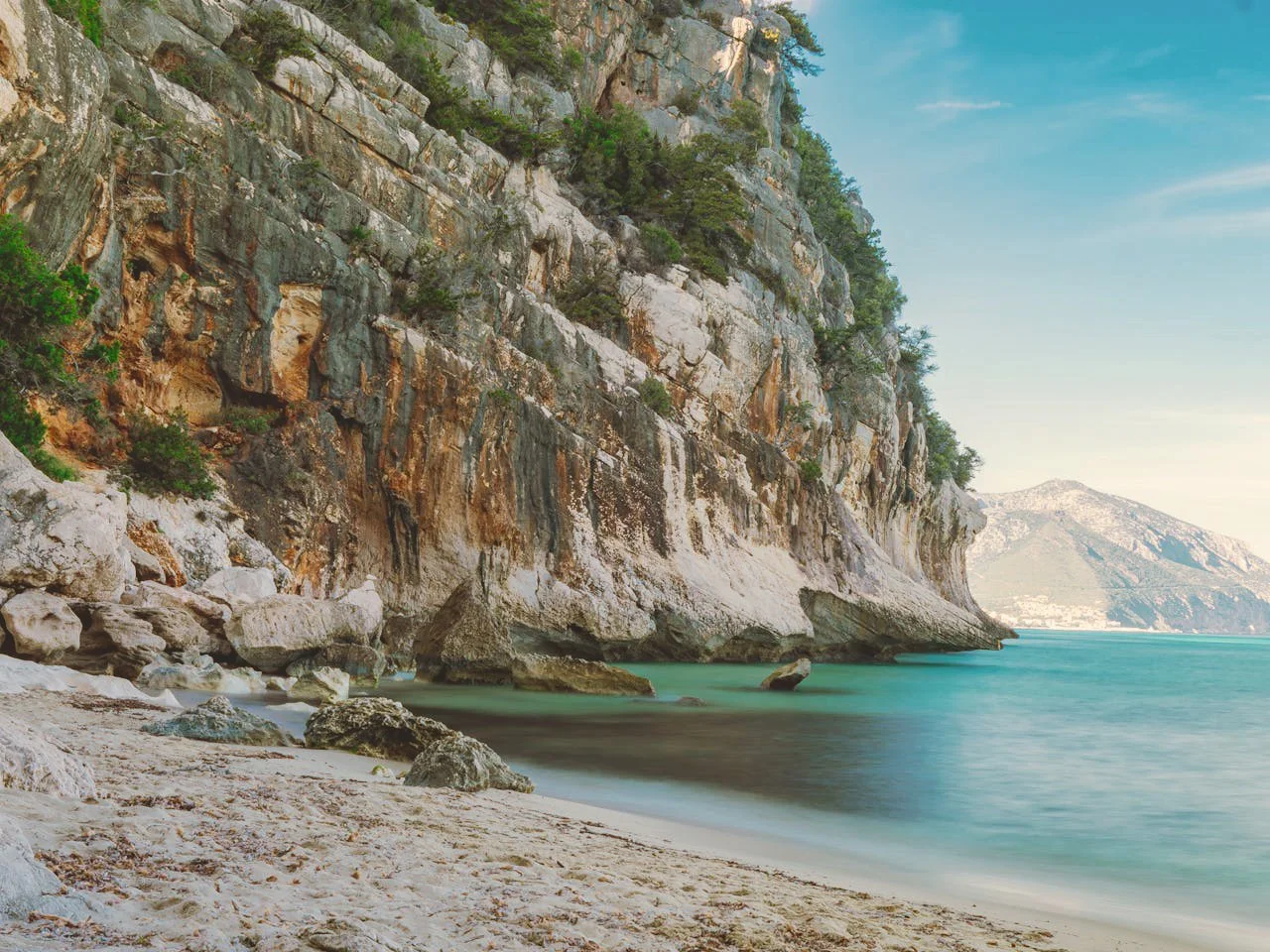Elopement photographer capturing a landscape view of the cliff and sea in Sardinia .