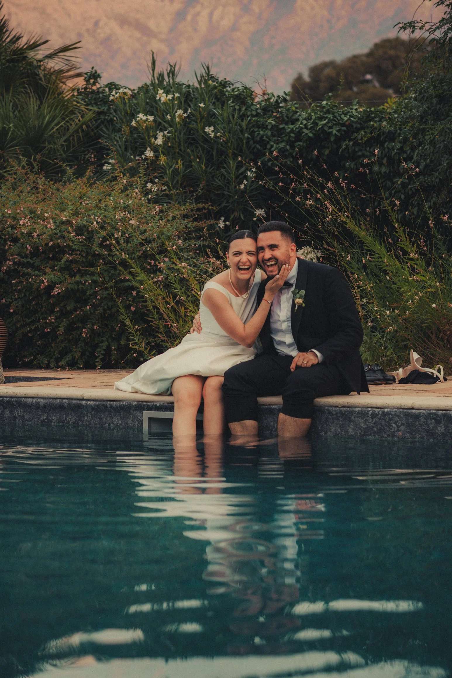 Couple relaxing by the pool with mountain views at a Corsica wedding