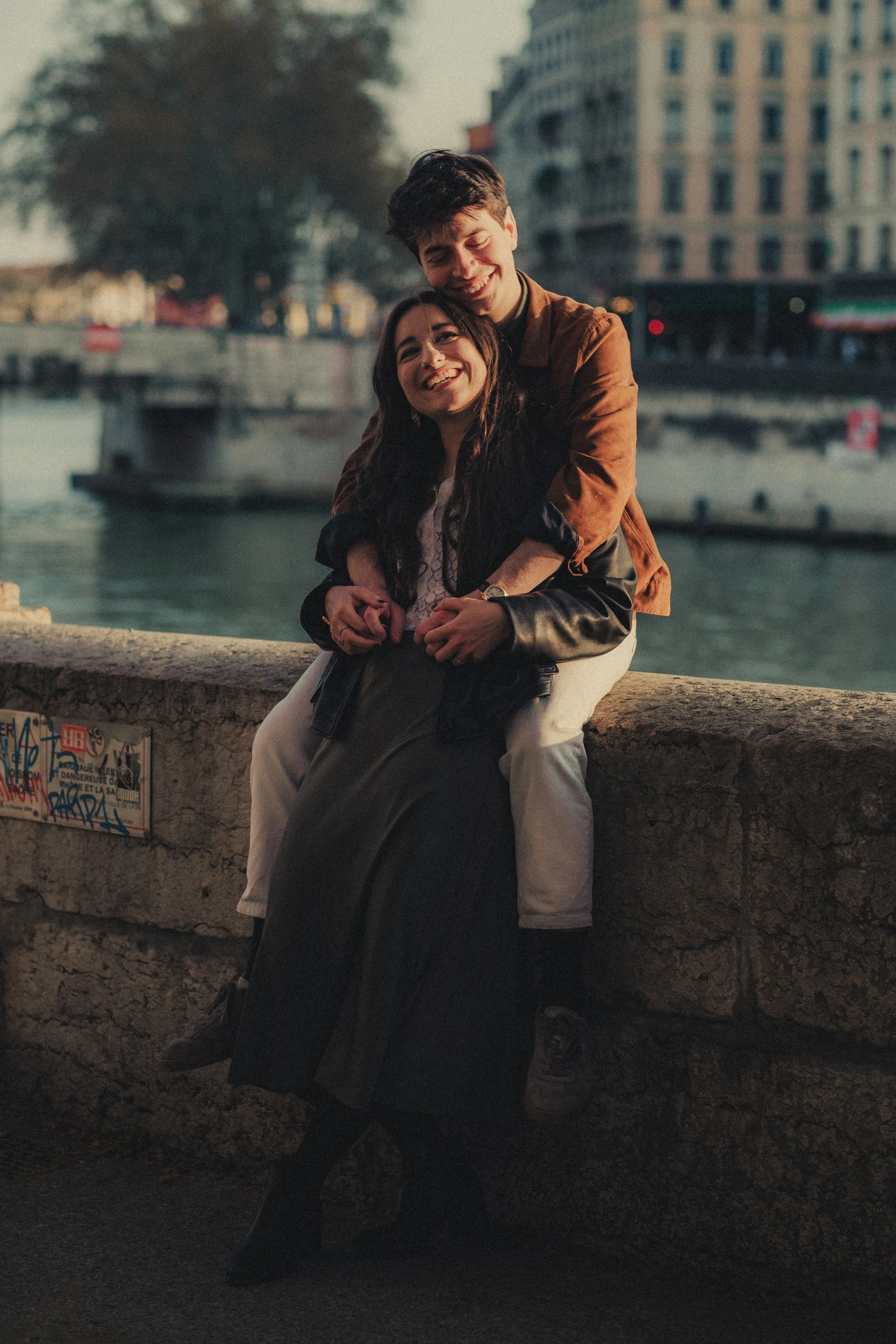 Couple enlacé souriant portrait urbain à Lyon.