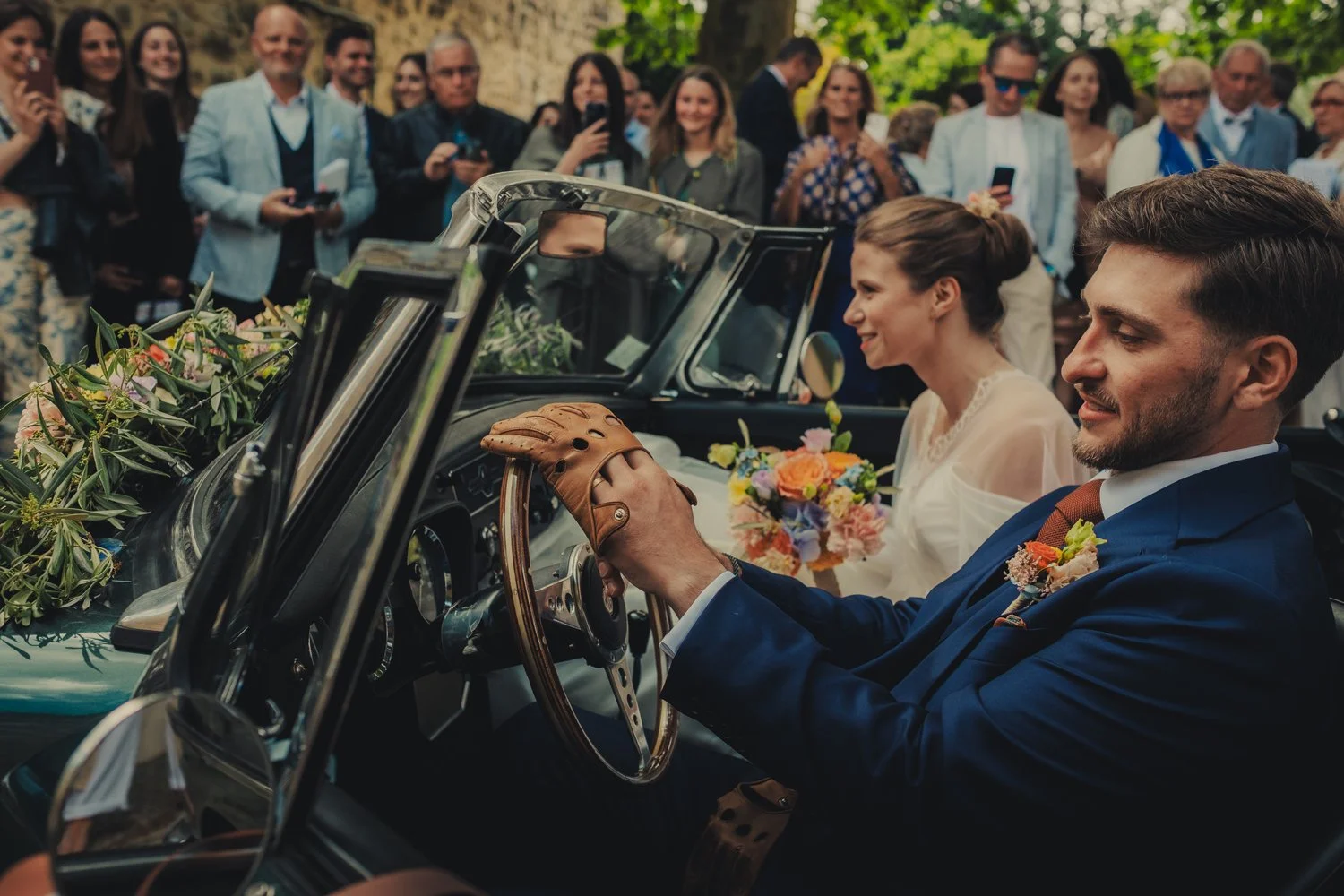 Mariés installés dans leur voiture vintage après la cérémonie