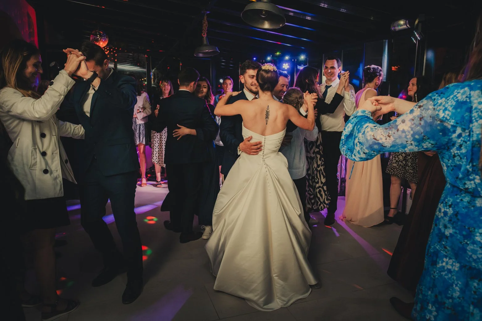 Mariés dansant une valse entourés de leurs invités