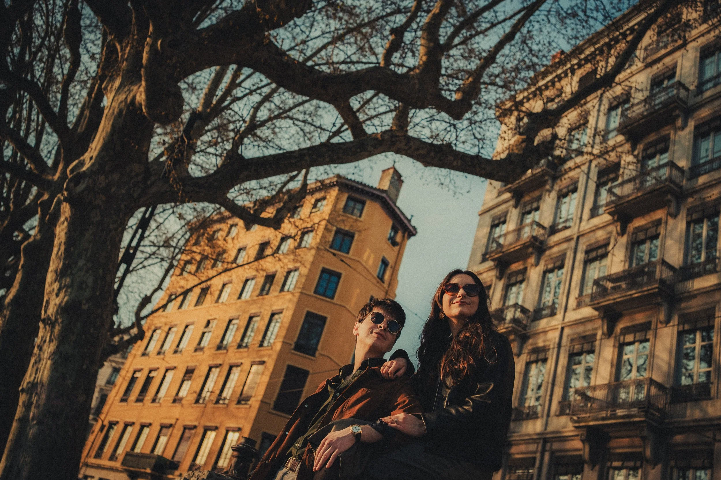 Couple stylé avec lunettes de soleil dans les rues de Lyon séance engagement urbaine.