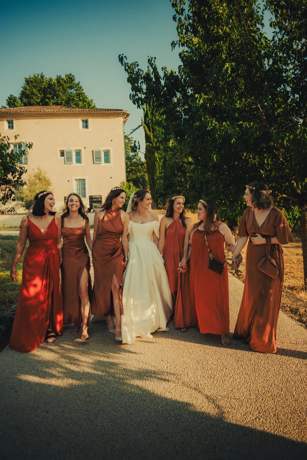 Bride and bridesmaids walking and smiling during their group photo moment.