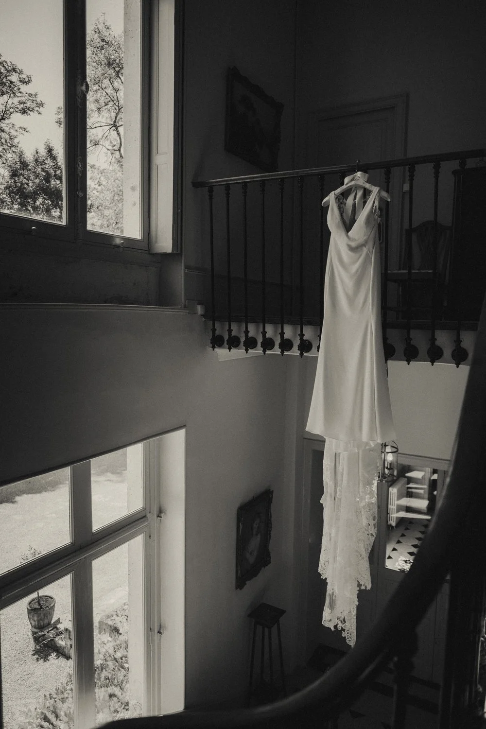 Wedding dress hanging on staircase inside Château La Gauterie