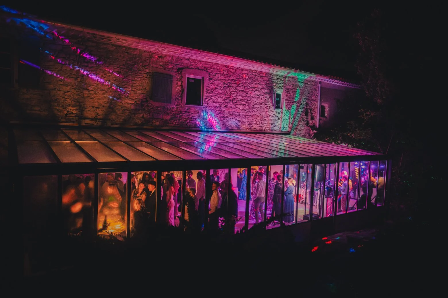 Réception de mariage illuminée par des néons et guirlandes au Domaine des Rives