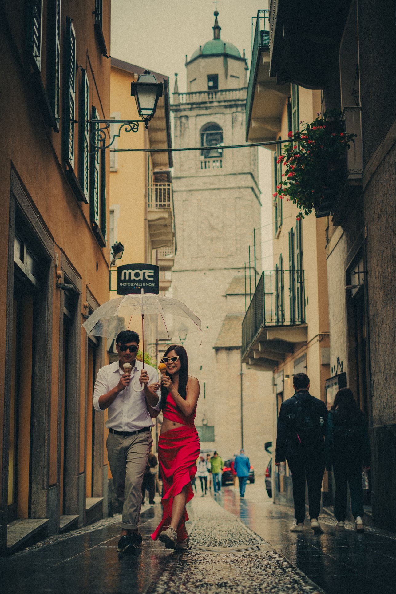 Couple having gelato ice-cream under the rain during their pre-wedding photo session in Lake Como.