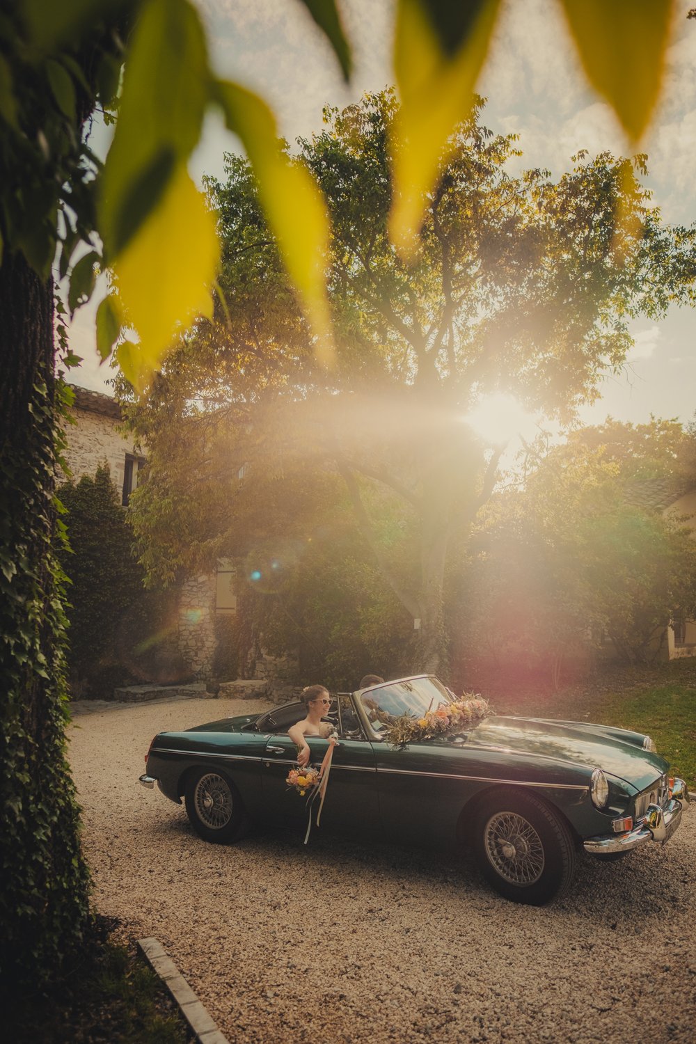 Séance couple au coucher du soleil avec voiture vintage lors d’un mariage au Domaine des Rives