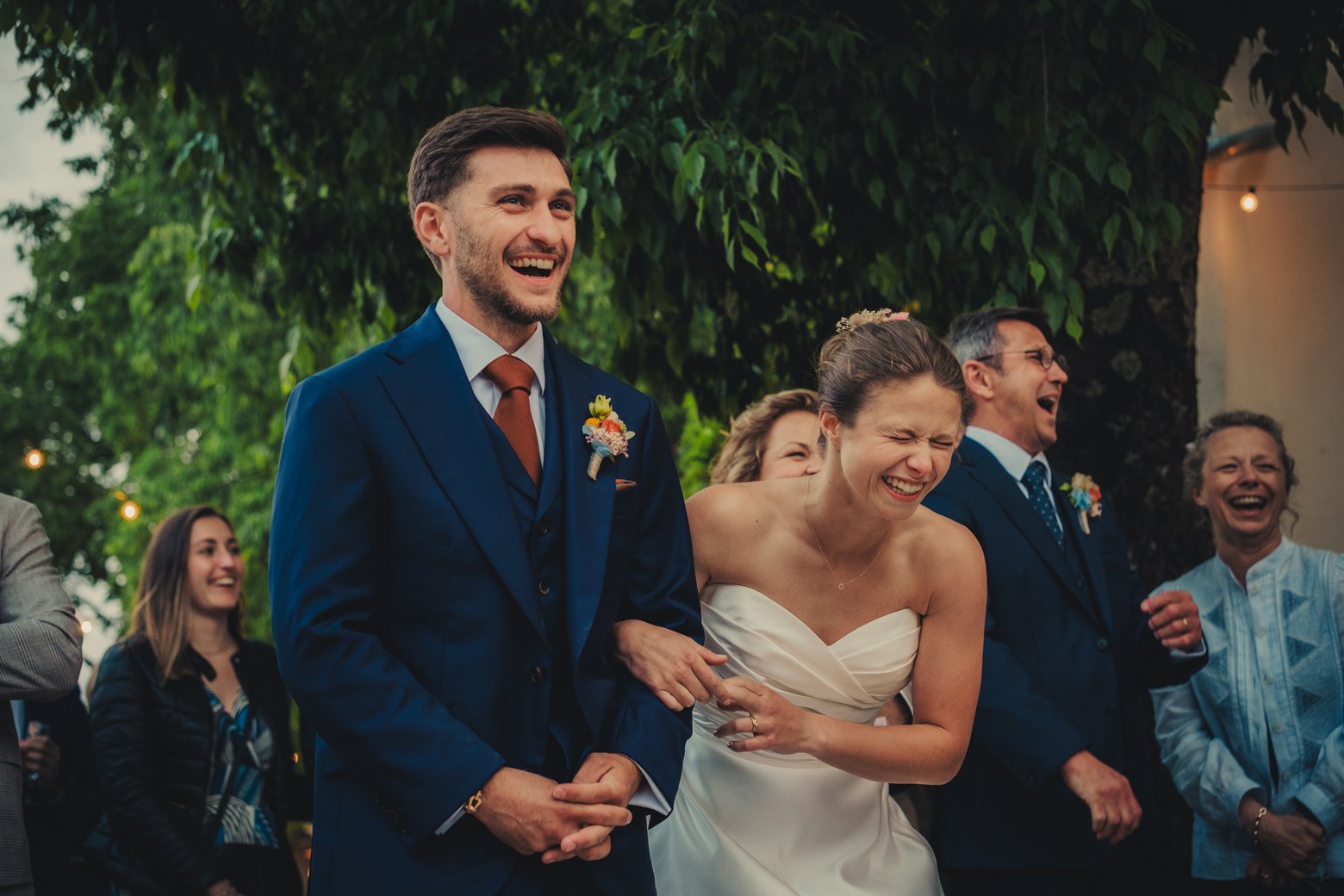 Couple de mariés riant pendant un discours lors du dîner