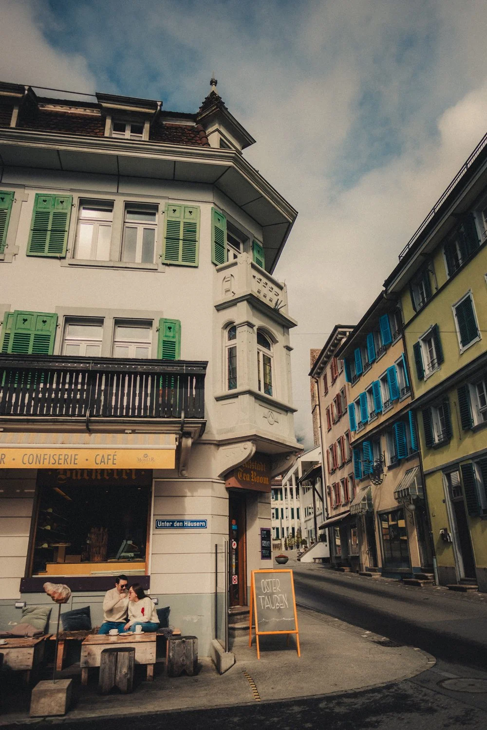 Couple sitting together outside a bakery during their Switzerland honeymoon.