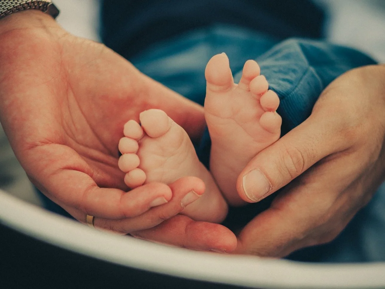 Gros plan sur les pieds d’un nouveau-né pendant une séance photo famille à Lyon