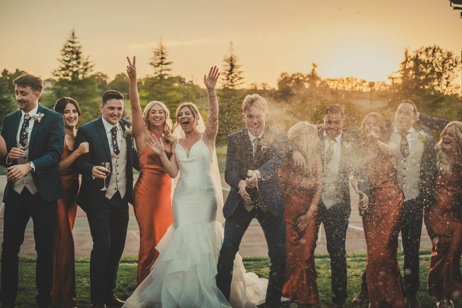 champagne pop sunset wedding bride groom friends