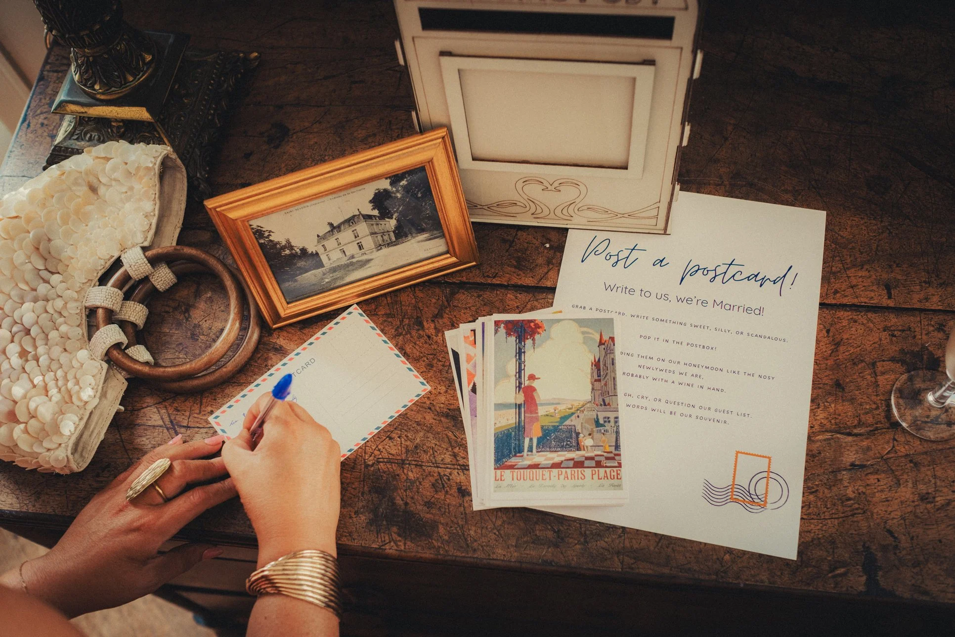 Guest writing postcard message during wedding reception