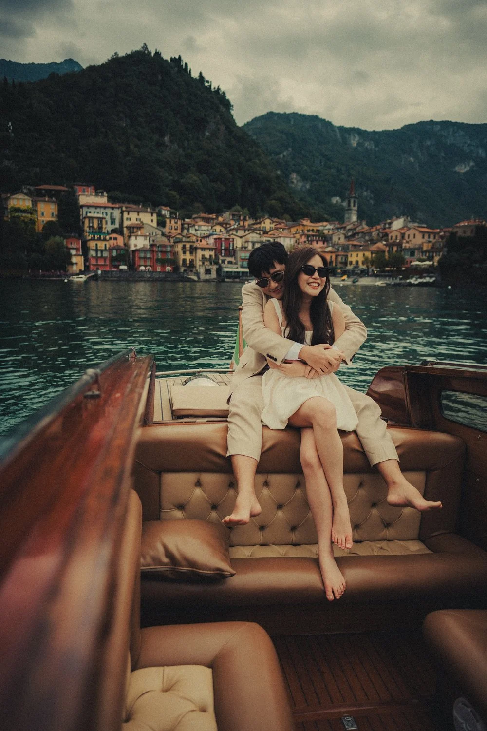 Couple hugging on a classic wooden boat during their engagement session in Lake Como.