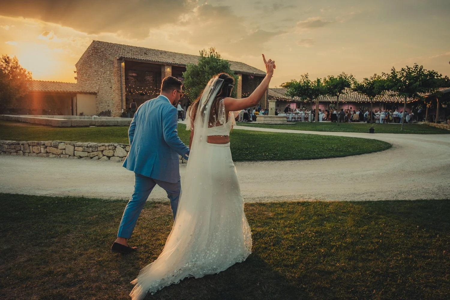Bride and groom entering the outdoor dining area with energy at Domaine de Sarson Provence.