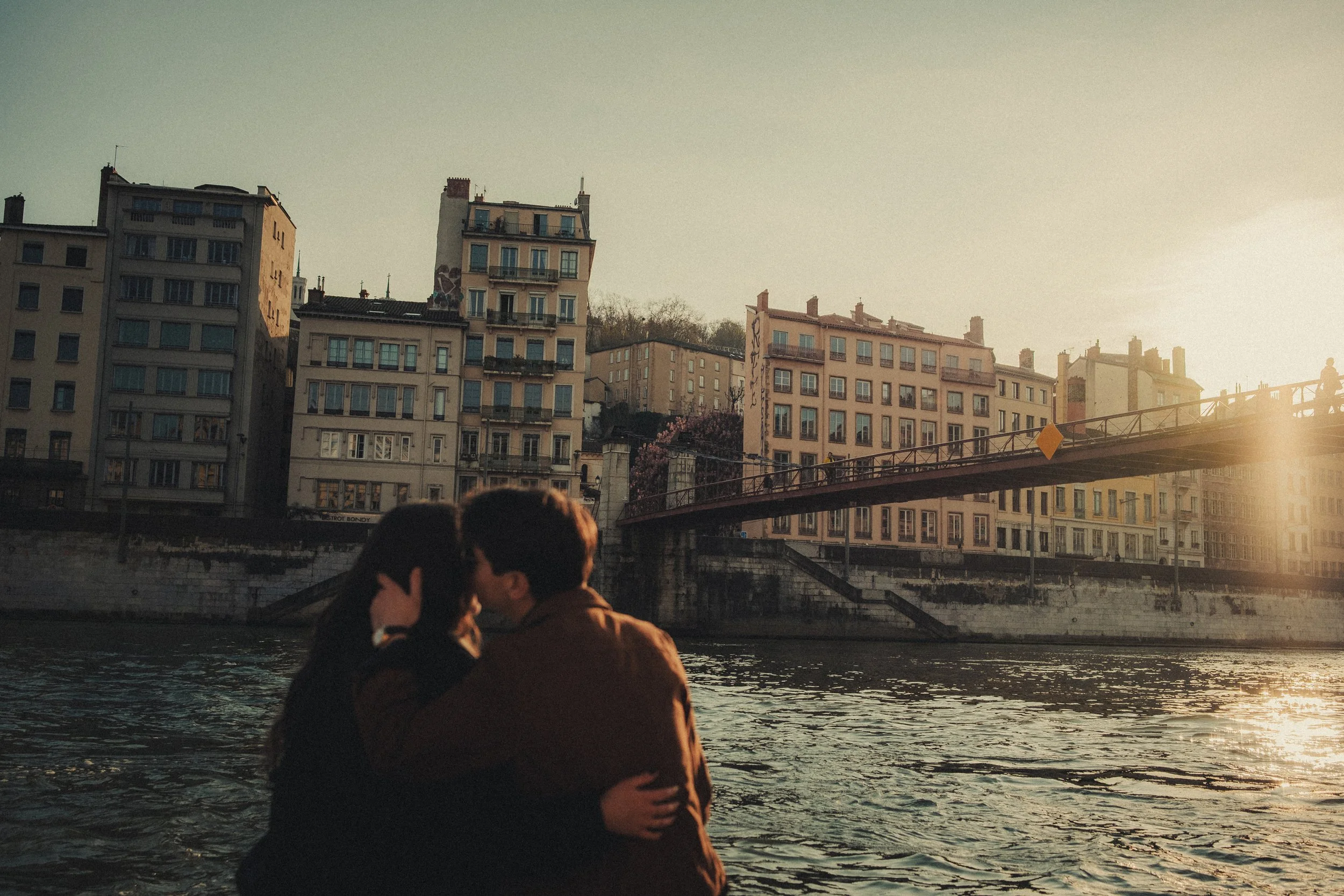 Couple s’embrassant au bord de la Saône à Lyon pendant la golden hour.