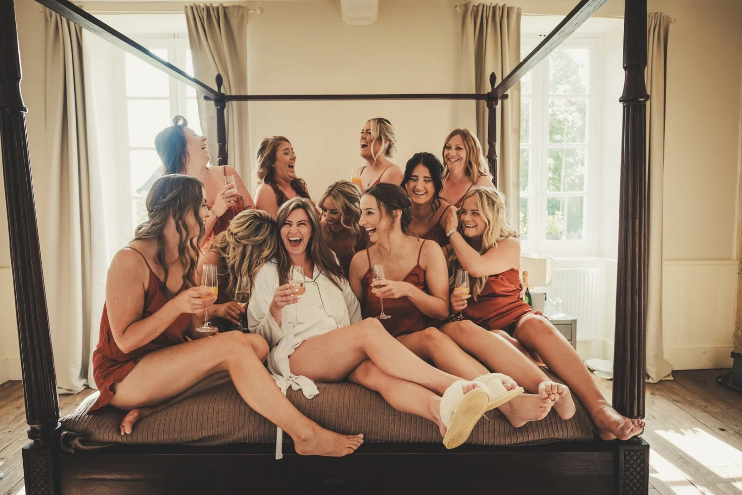 bride having fun with bridesmaids wedding prep manoir de longeveau