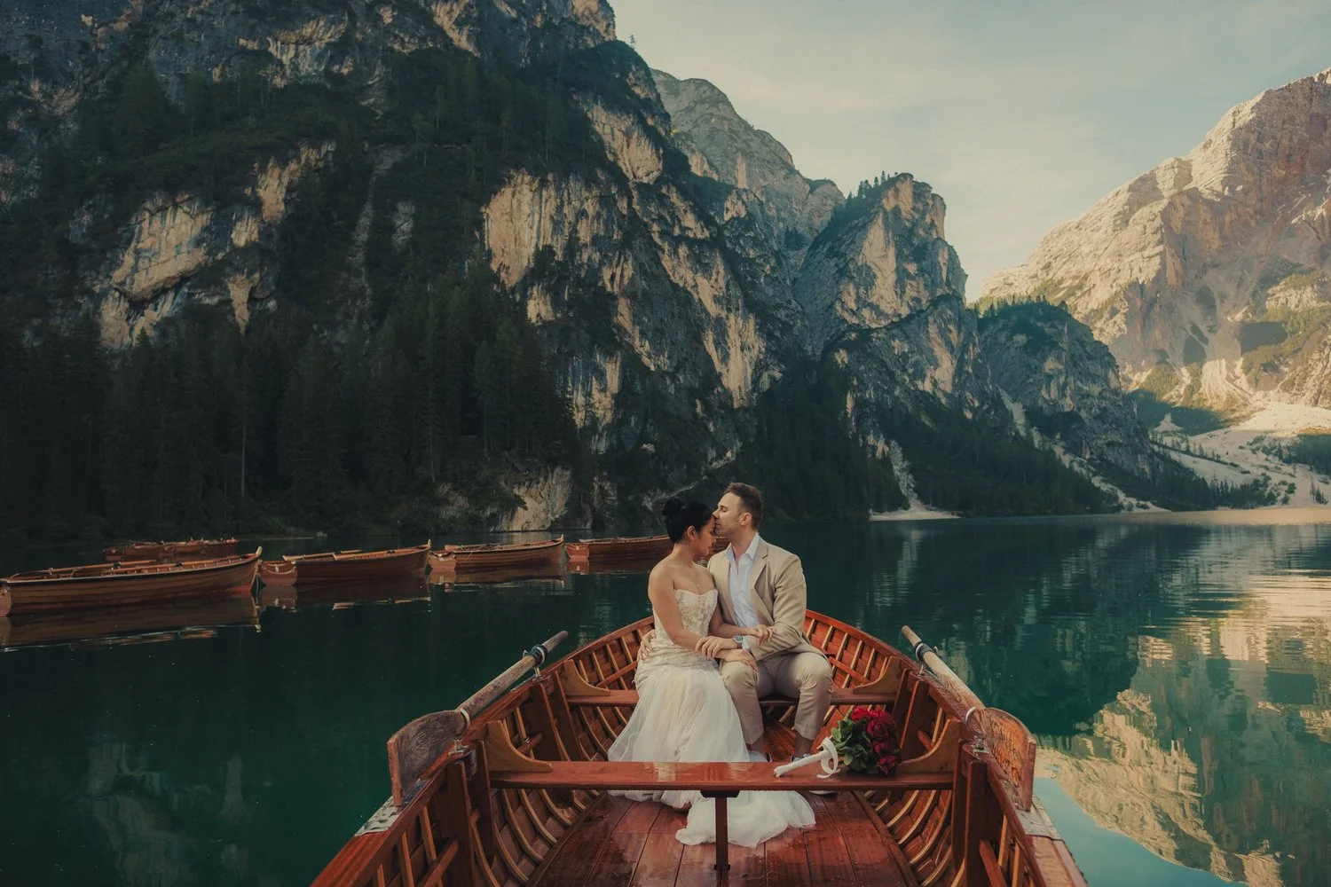 couple kissed in the wooden boat during their elopement in lago di braies
