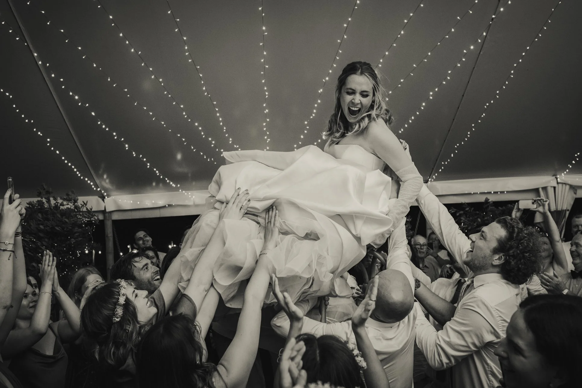 Fun moment of bride getting lifted by friends at the wedding in Provence.