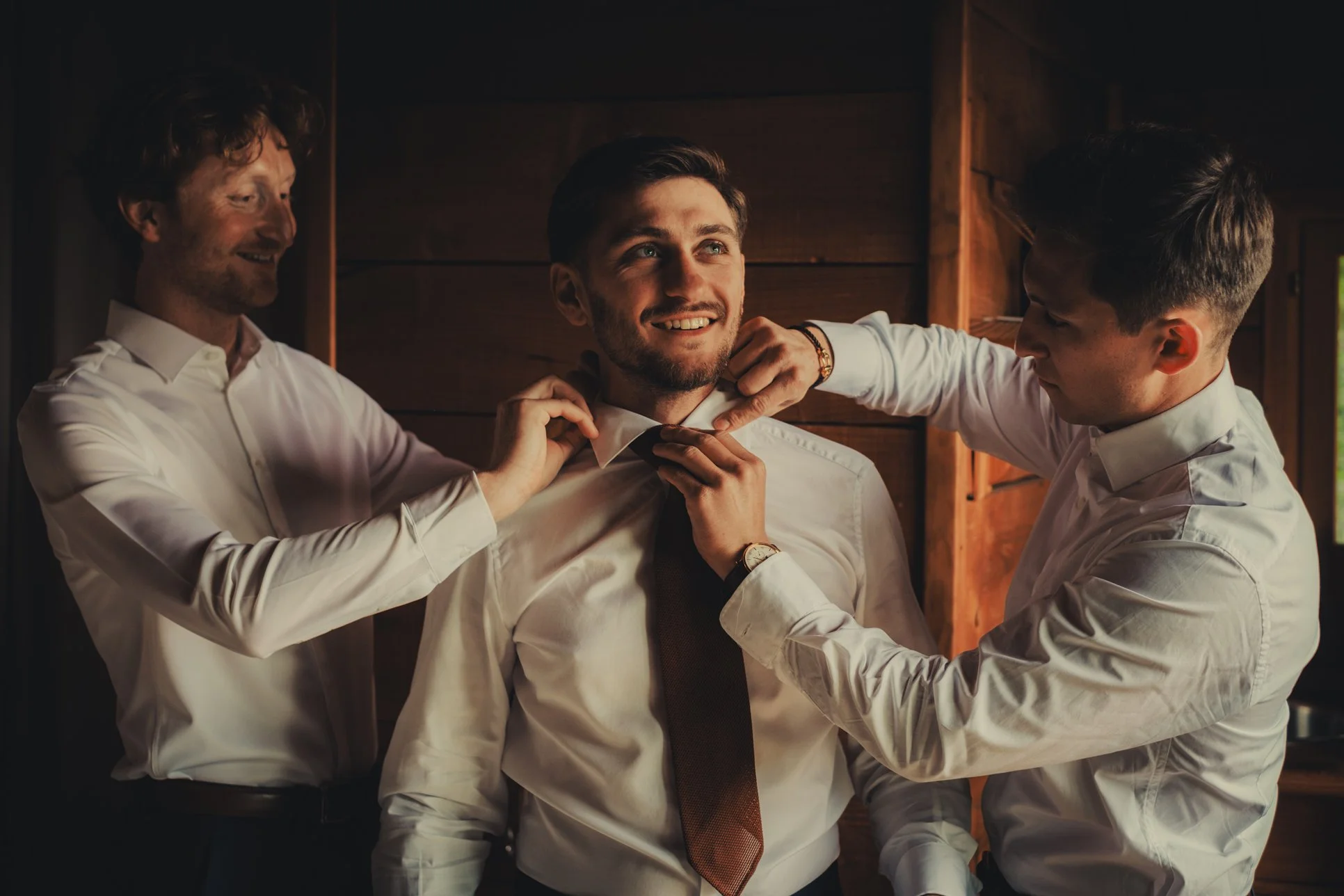 Marié aidé par ses proches pour enfiler son costume avant la cérémonie