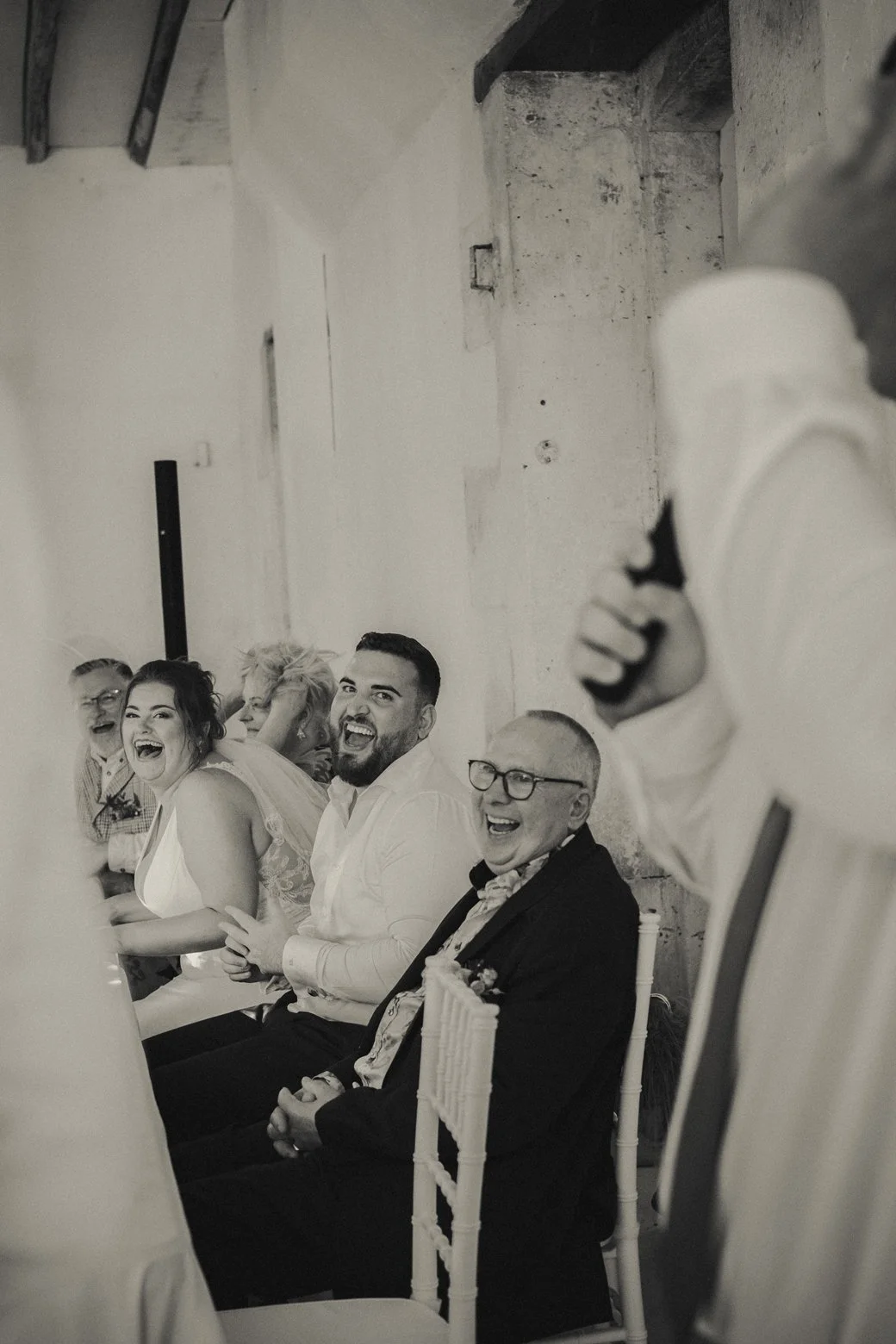 Bride and groom laughing during heartfelt wedding speech