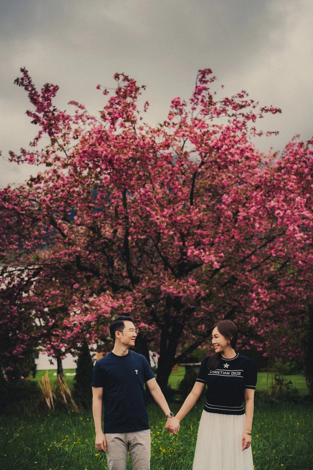 Couple smiling together in front of blooming spring flowers in Interlaken.