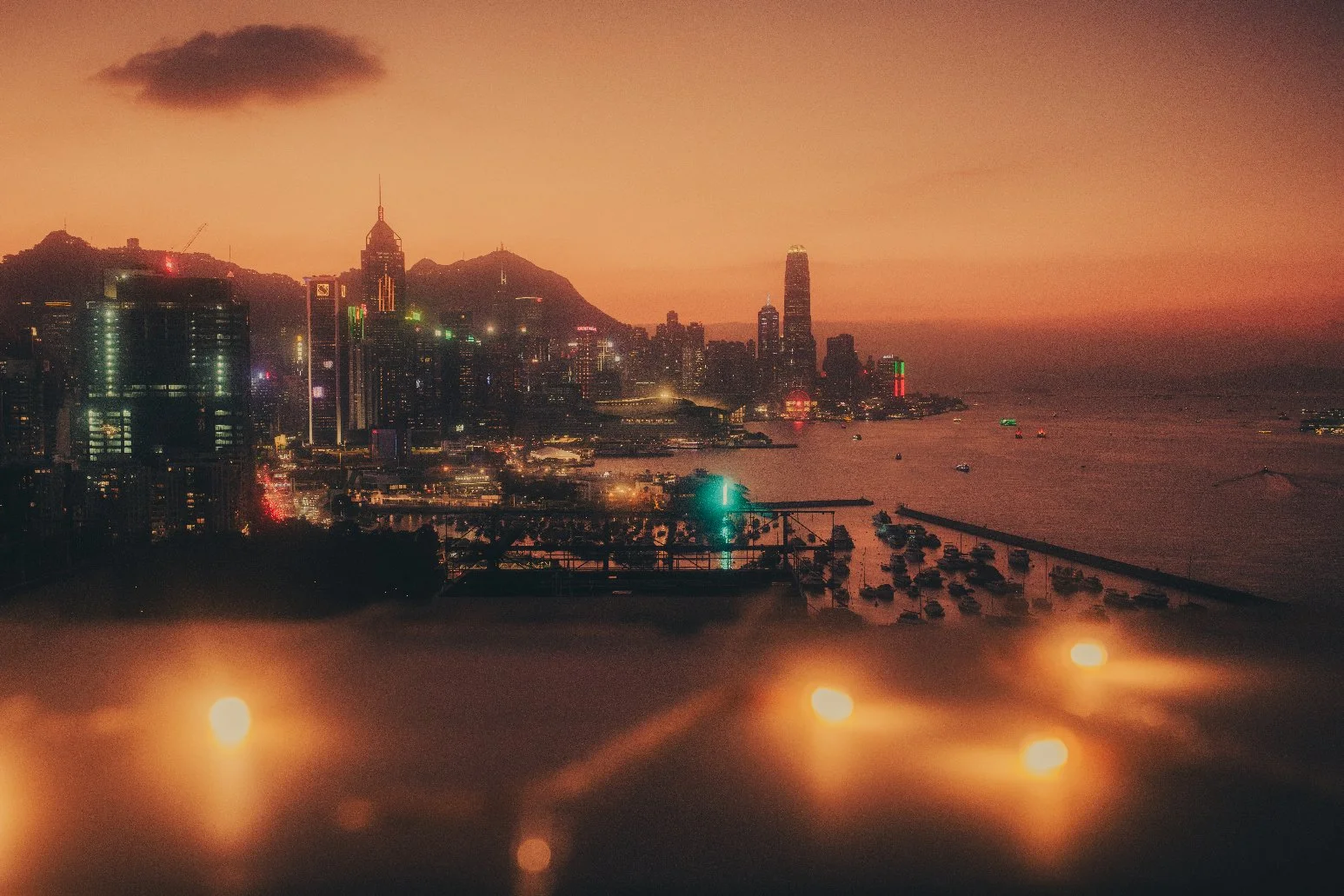 Elopement photographer capturing a landscape sunset moment in Hong Kong with a city lighting up next to the harbour.