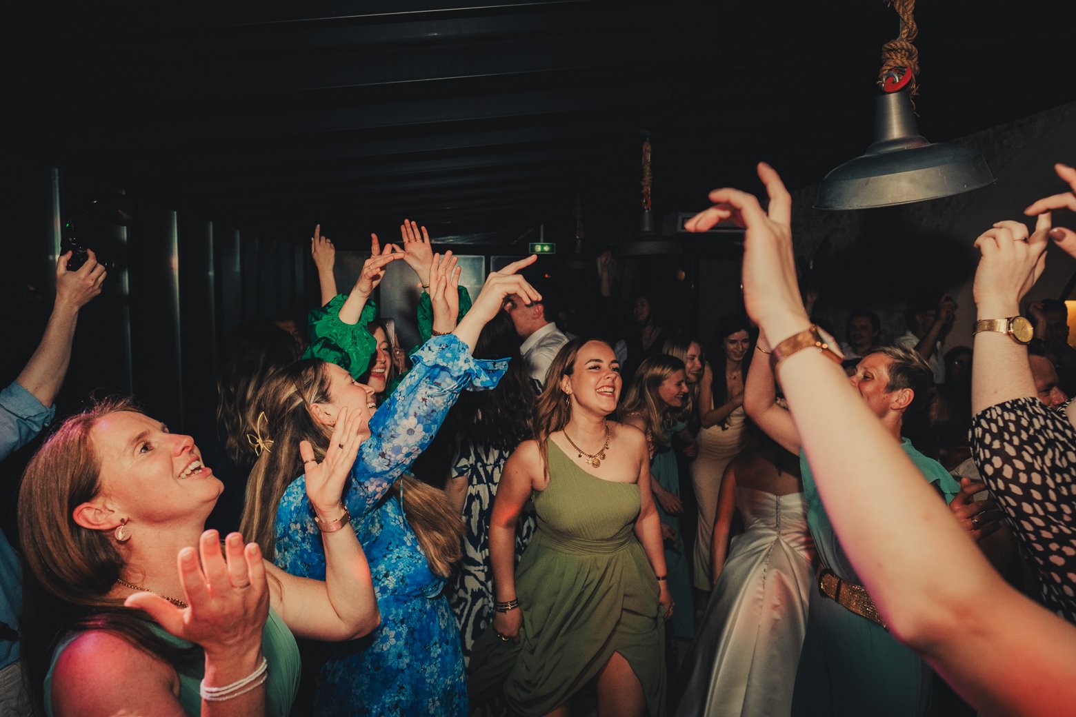 Invités dansant avec énergie pendant la soirée de mariage