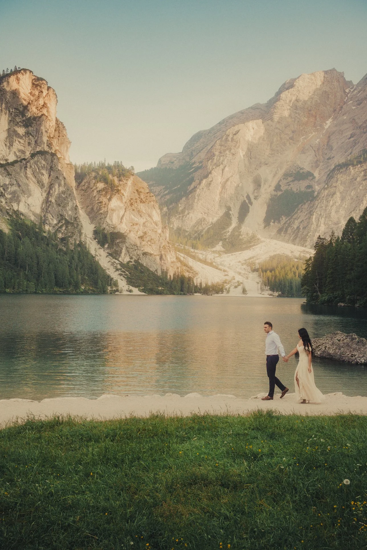 Dolomites elopement photographer capturing a couple walking at Lago di Braies.