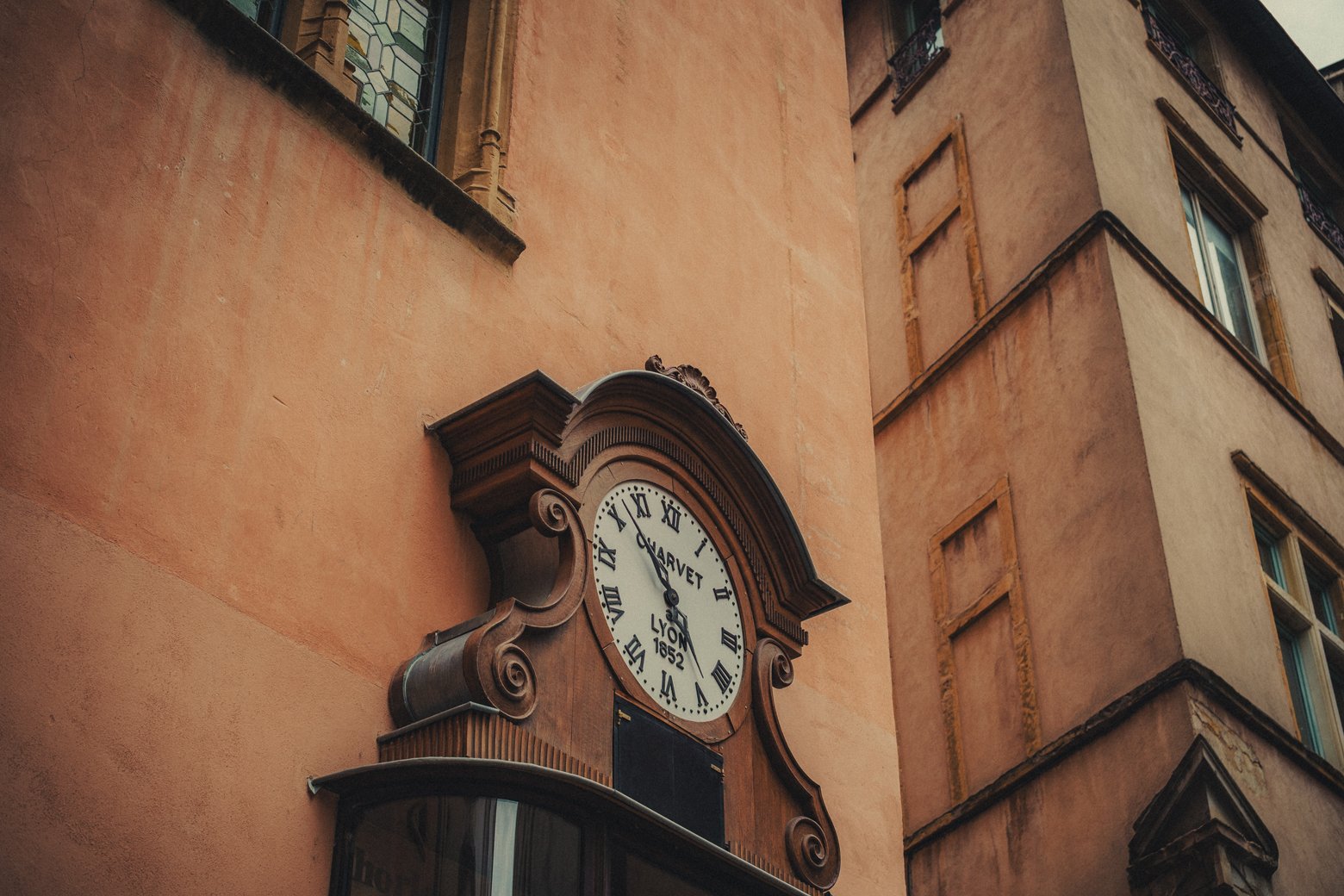 Horloge en bois suspendue dans une rue du Vieux Lyon