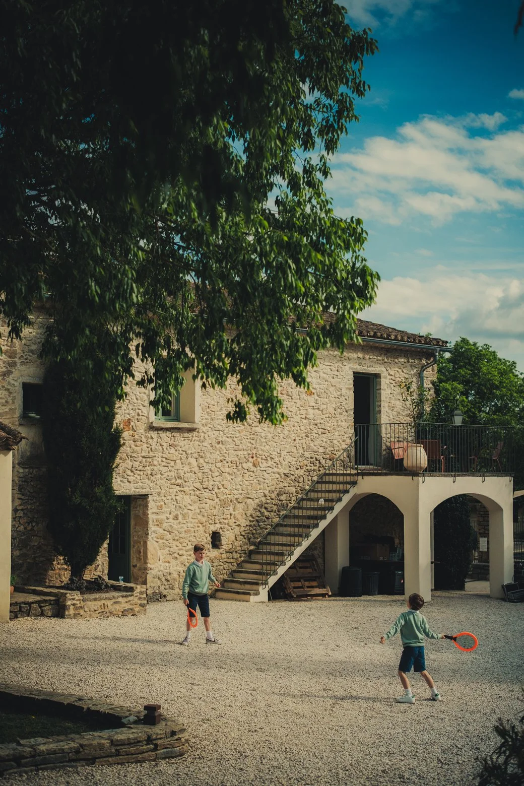 Enfants jouant dans le jardin avec le Domaine des Rives en arrière-plan