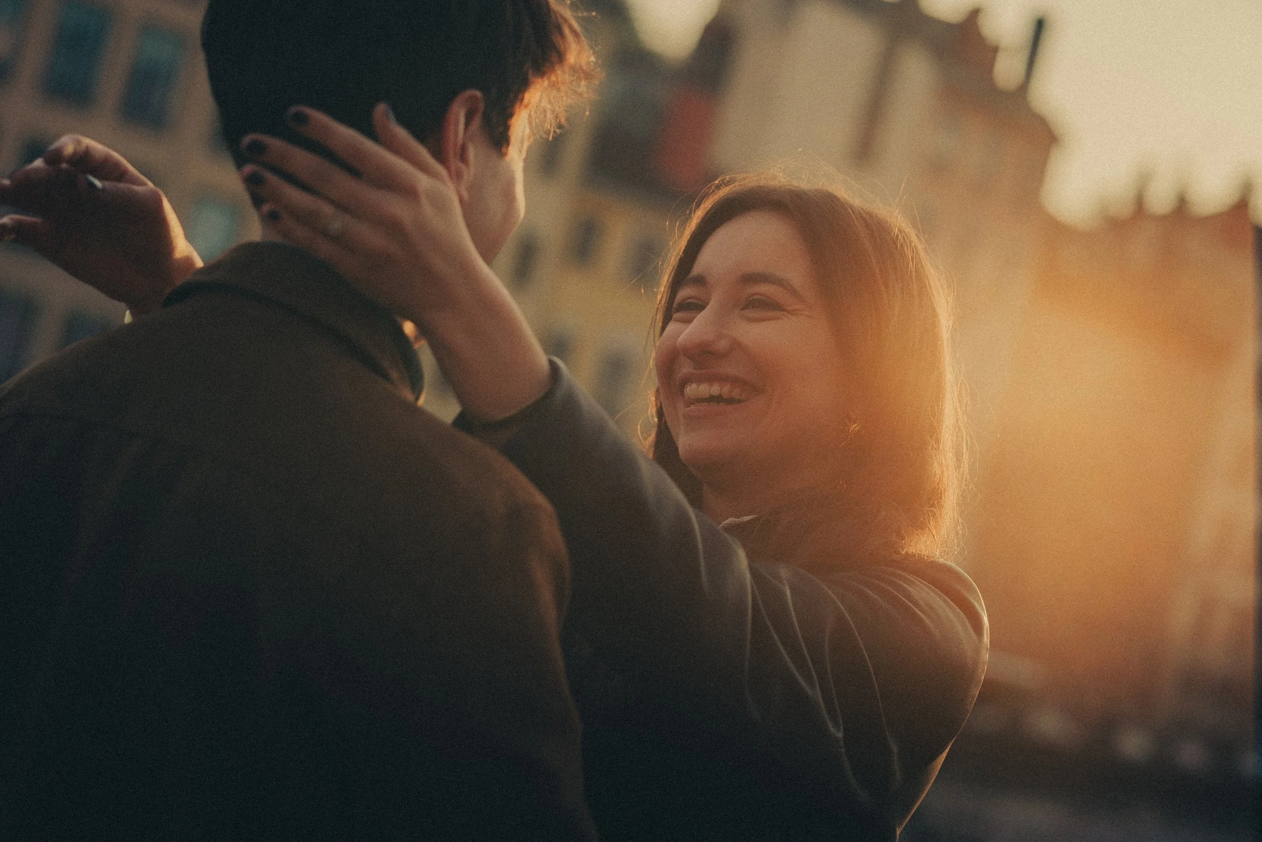 Future mariée regardant son fiancé en souriant au coucher du soleil à Lyon.