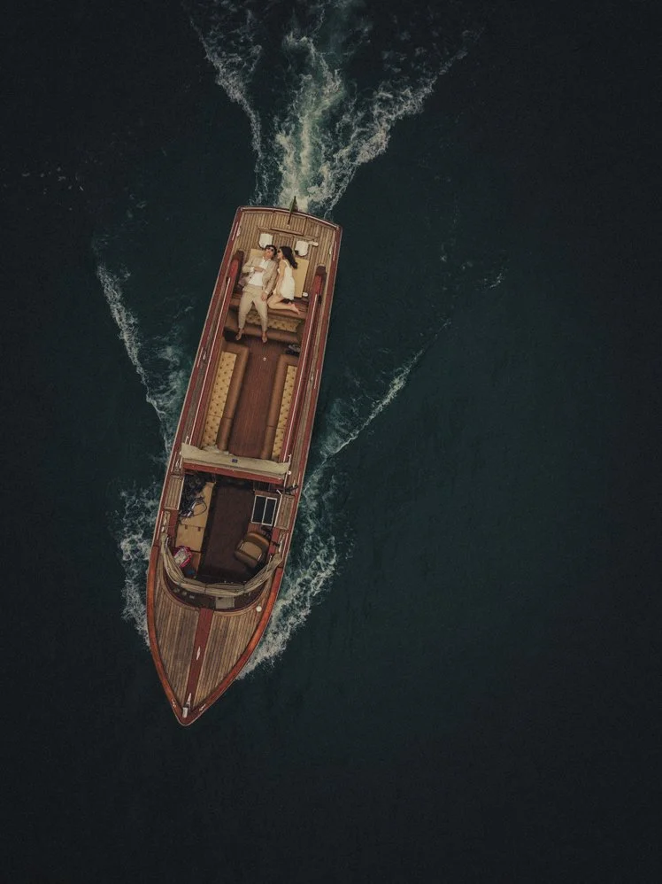 lake como elopement photographer capturing a couple on a wooden boat with a drone.