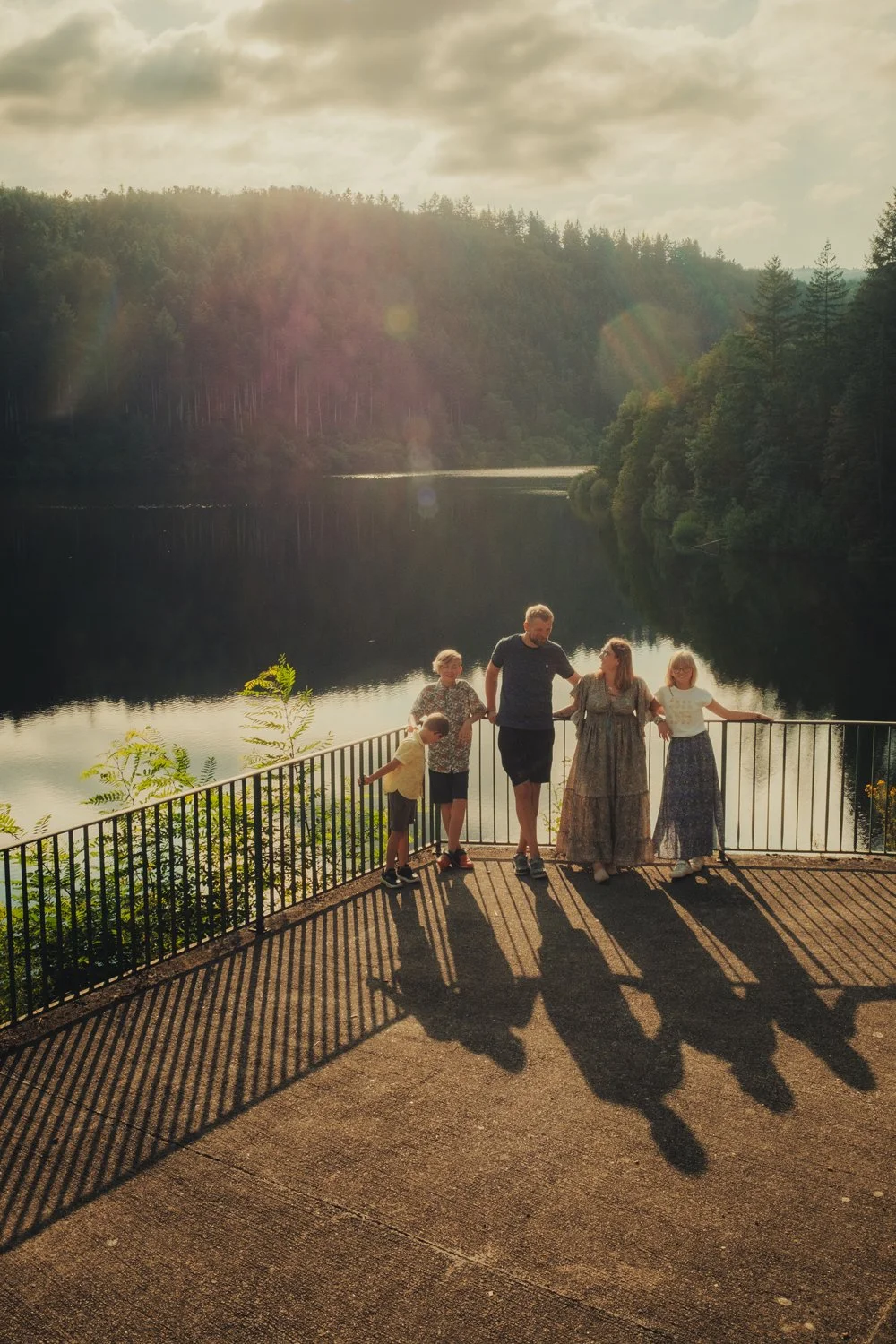 Famille profitant de la lumière dorée lors d'une séance photo famille au barrage de Renaison