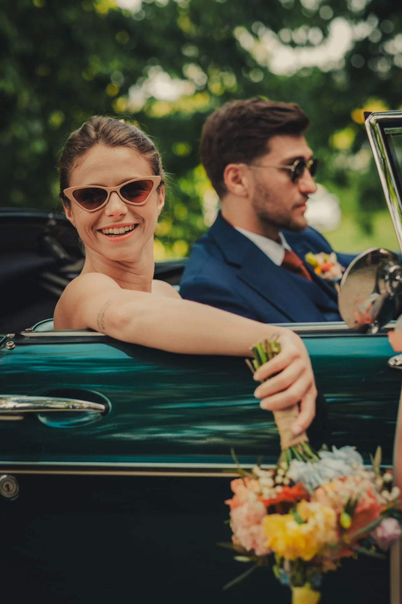 Les mariés posant dans de leur voiture vintage au Domaine des Rives