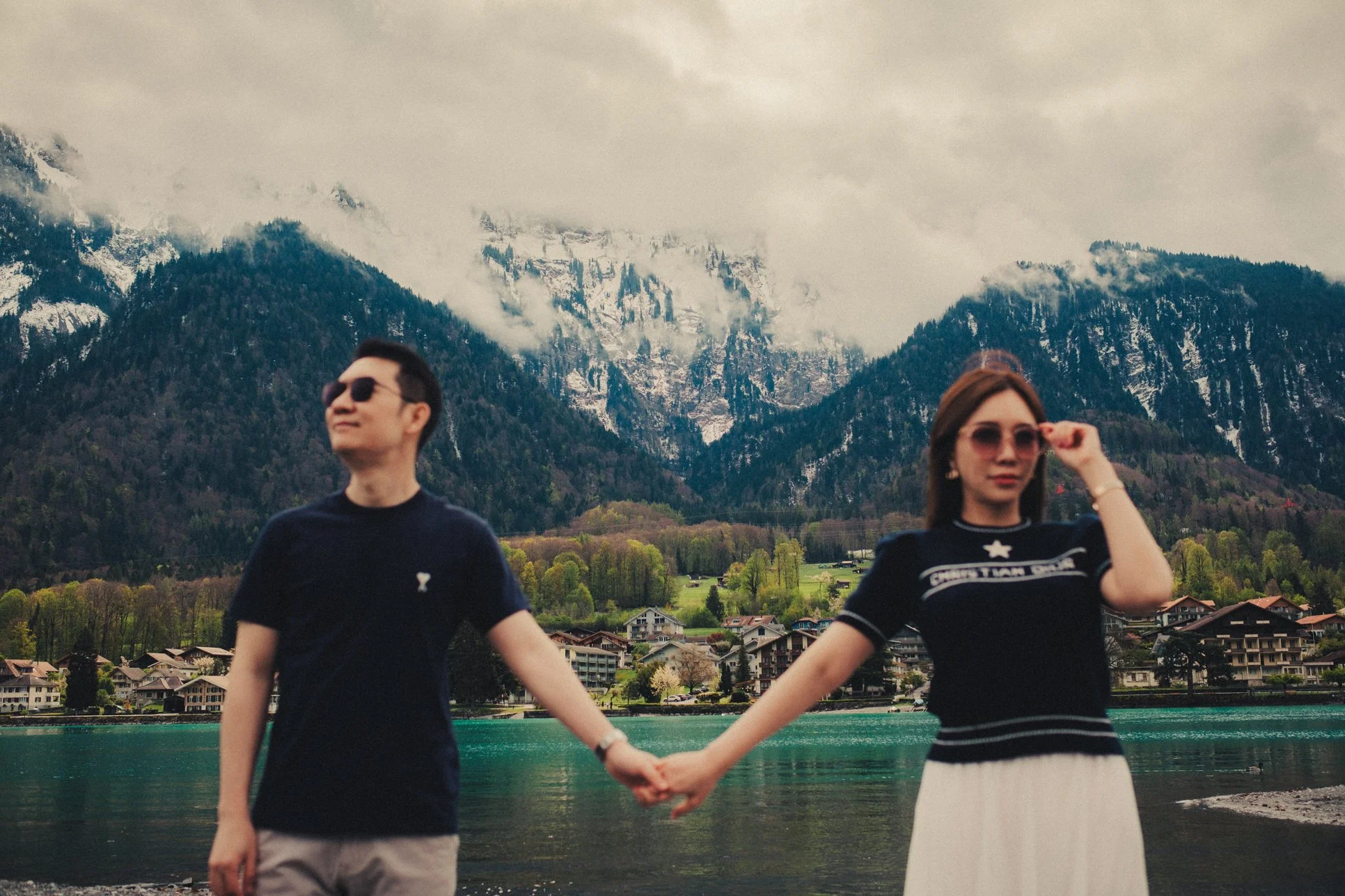 Couple with snow-capped mountains overlooking Lake Brienz.
