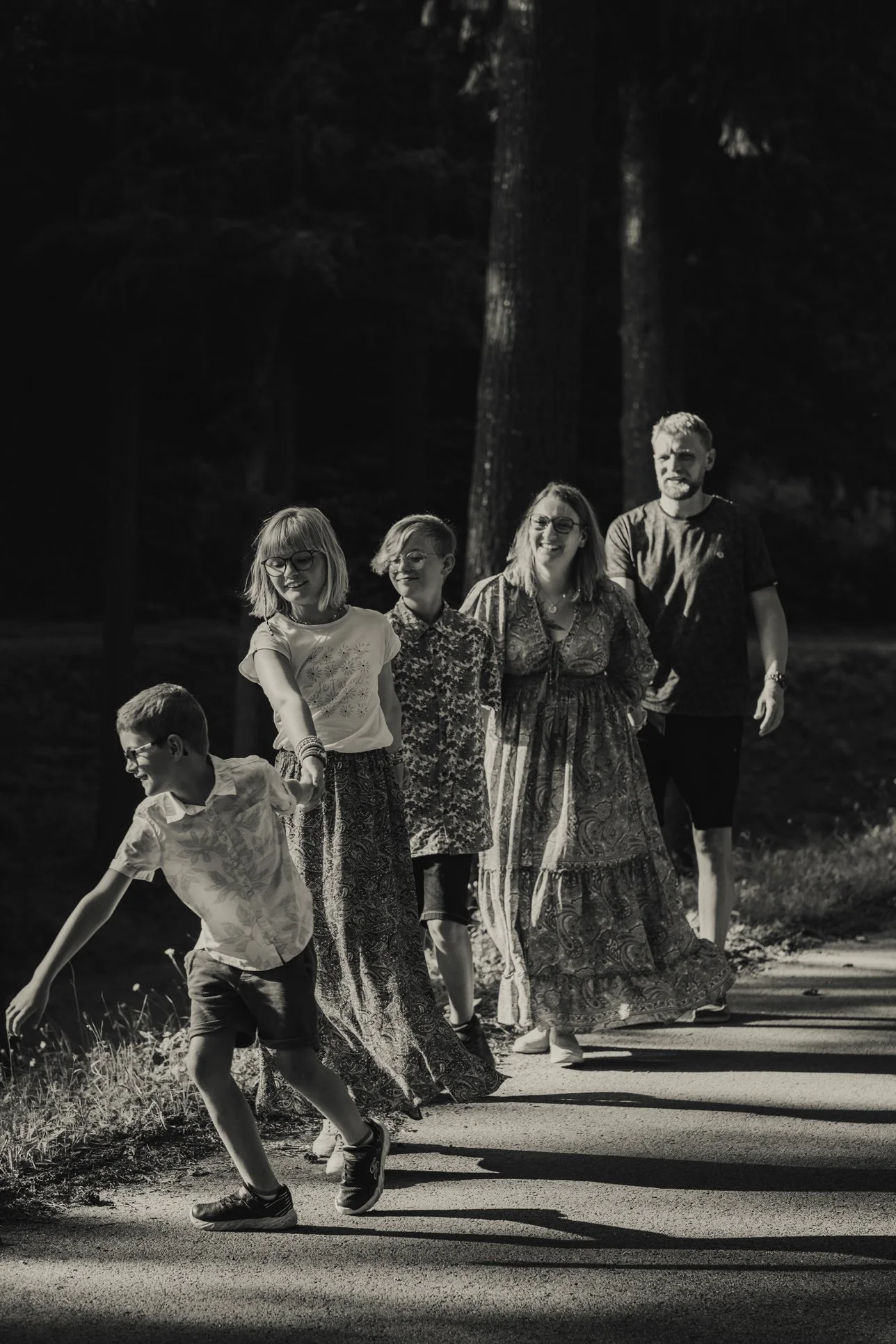 Parents et enfants marchant dans la nature pendant une séance photo famille dans le Roannais