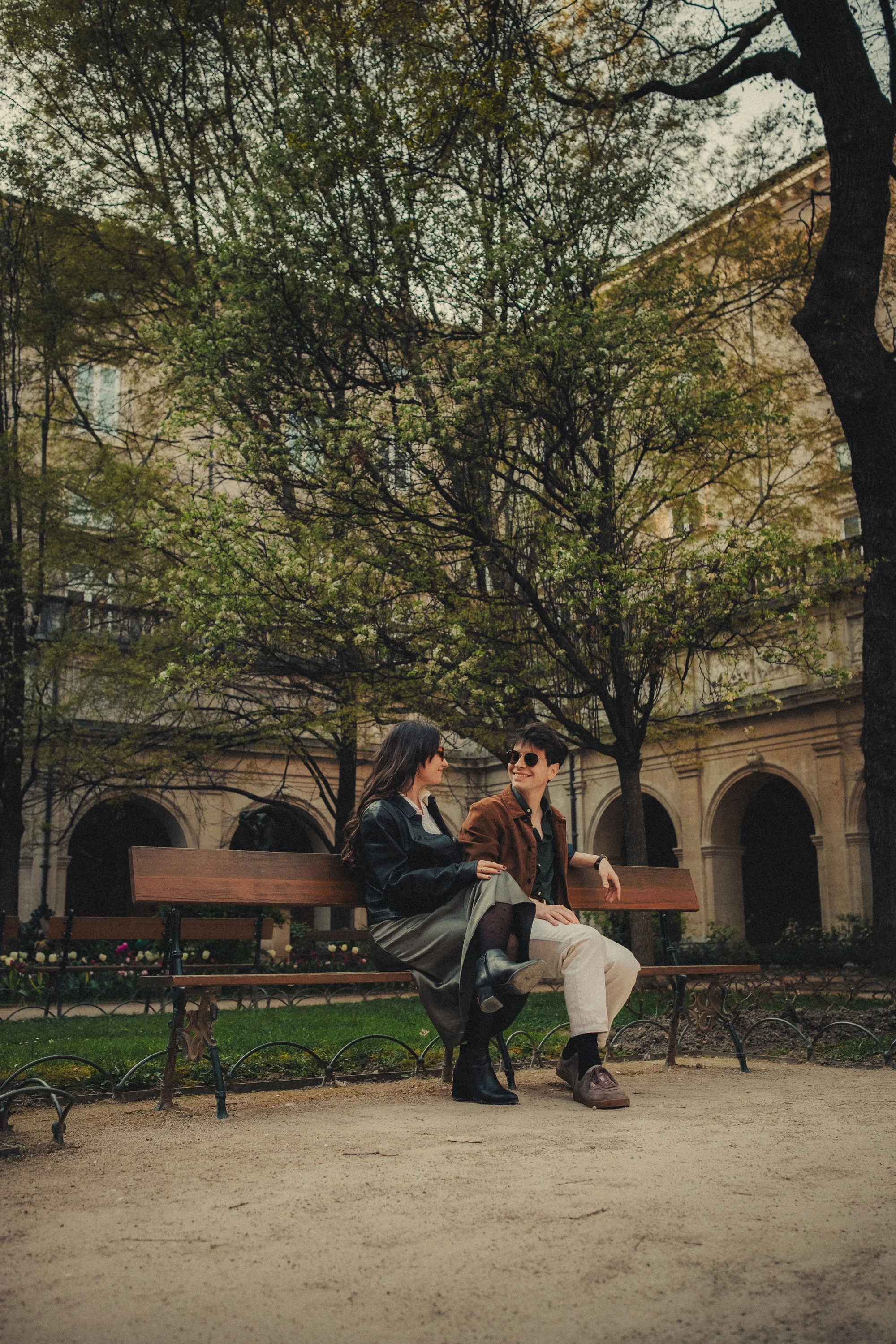 Futurs mariés assis ensemble sur un banc dans le jardin de Musée des Beaux-Arts de Lyon.