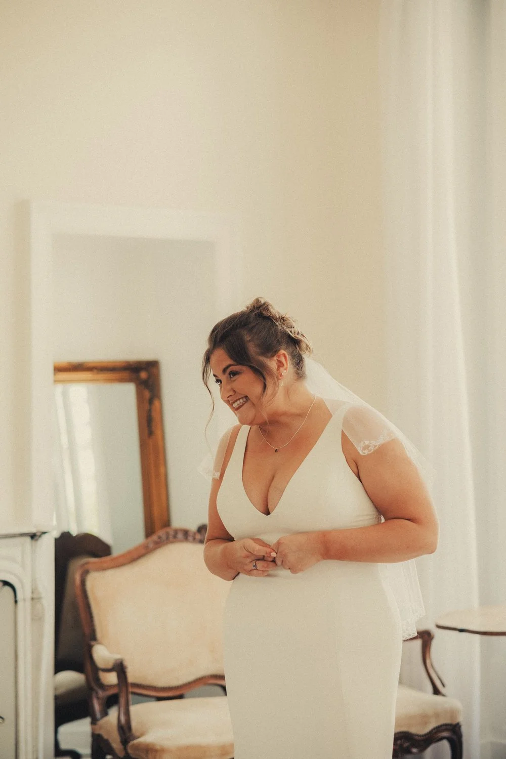 Bride smiling during first look with her father at château wedding