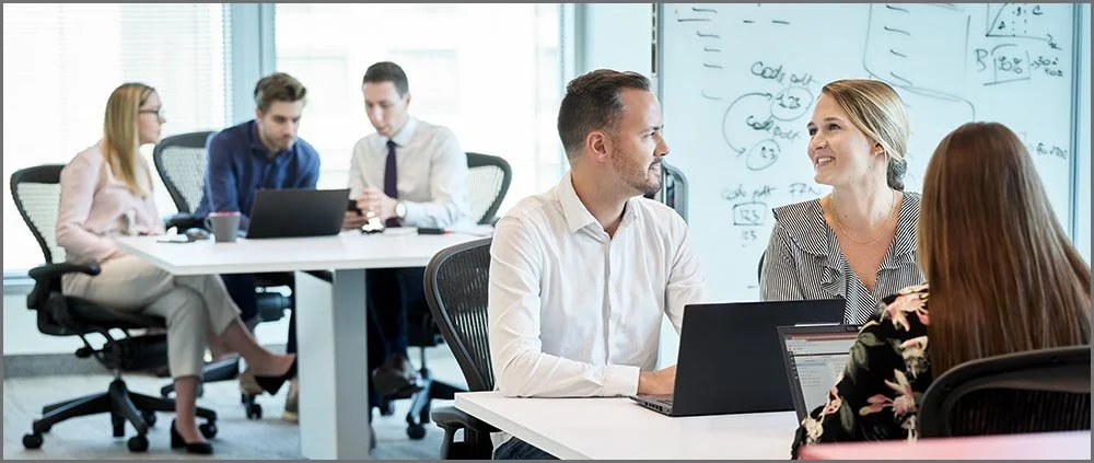 coworkers discussing work in open concept office.jpg