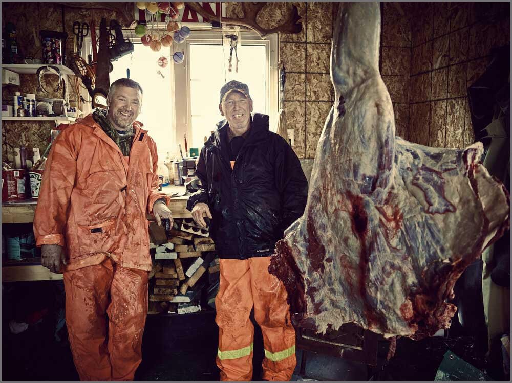 personal project portrait of men with hanging moose quarters.jpg