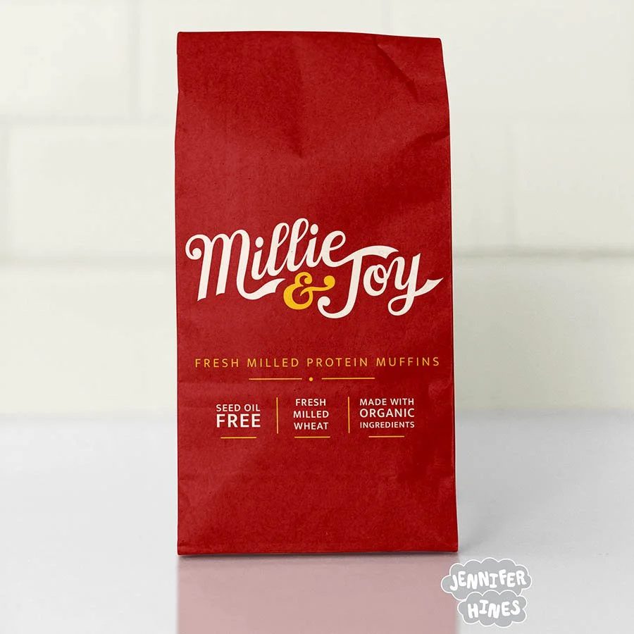 Image of a bag of protein muffins with the baking company Millie & Joy hand lettered logo on it