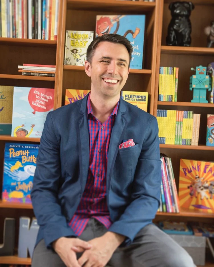 Jarrett_J_Krosoczka_laughing_in_front_of_bookshelf_photo_by_Derek_Fowles.jpg