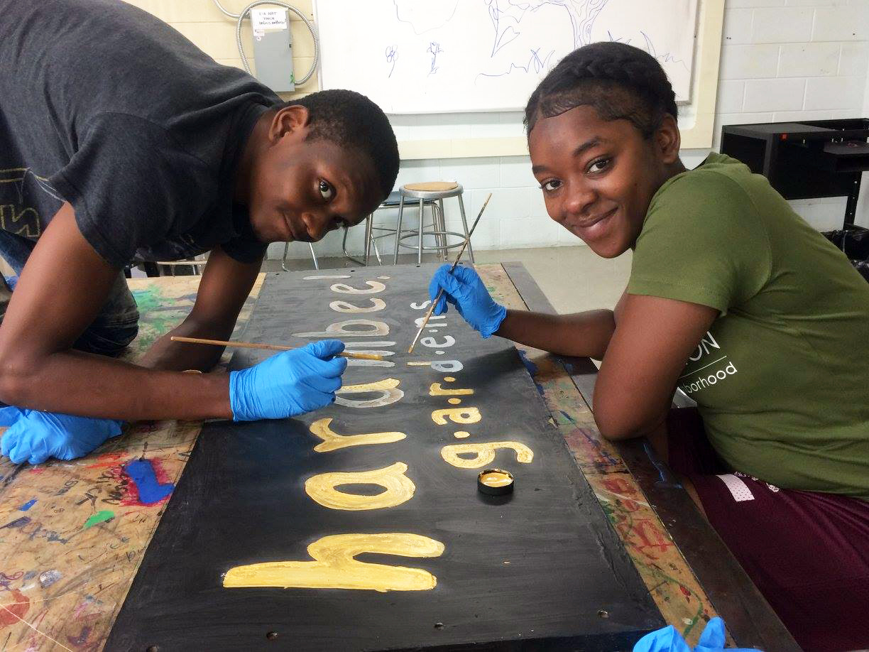 Participants paint new signs for the Harambee Garden.
